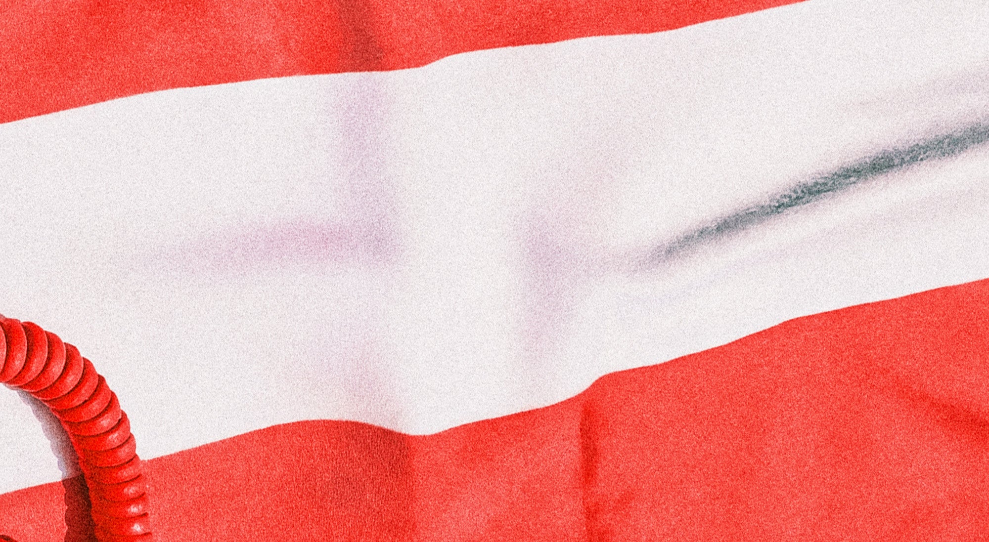 Close-up of red and white striped fabric with a coiled red object on top.