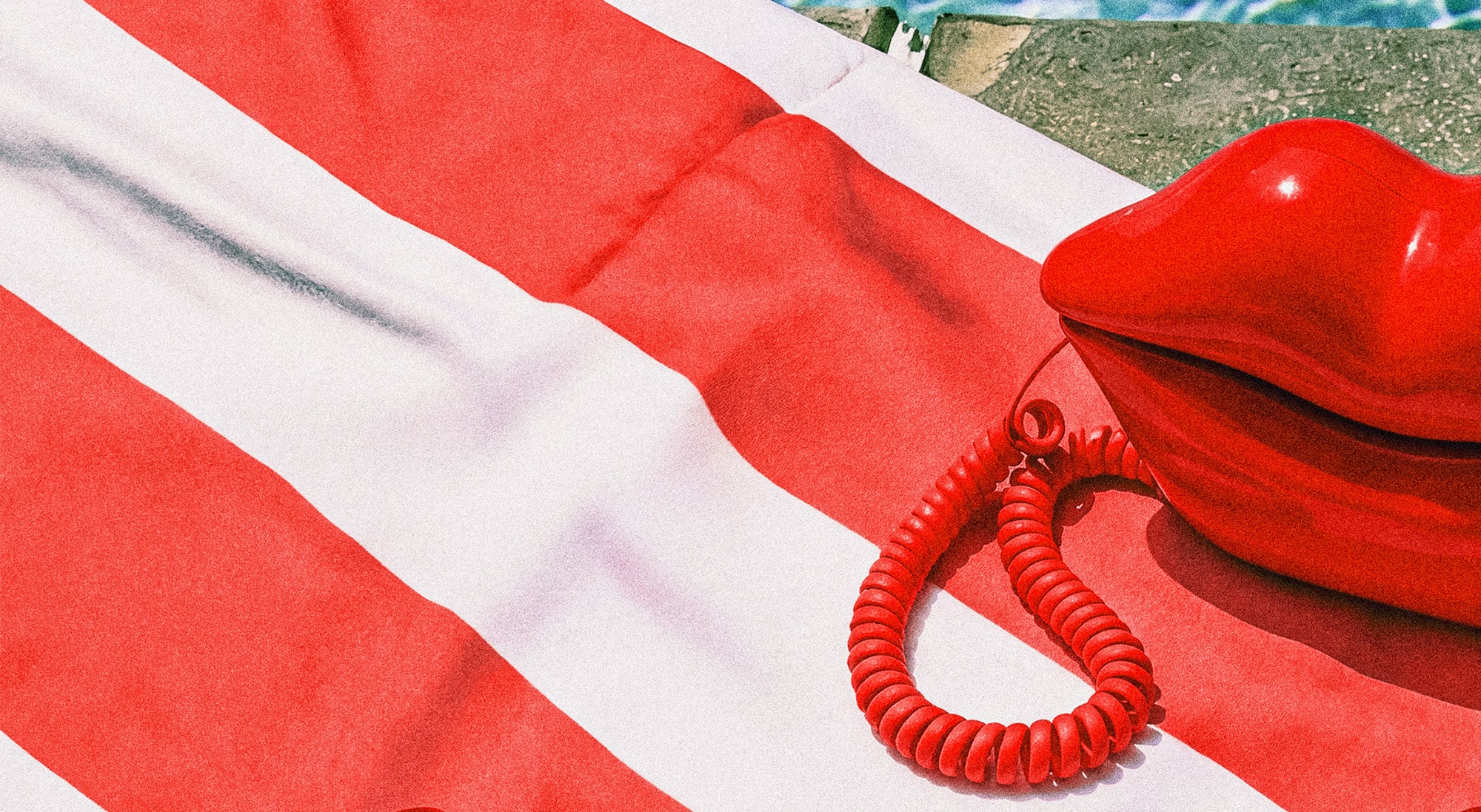 Red and white striped towel with a red inflatable pool toy on a grassy background