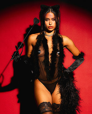 Person in a black cat-themed outfit with a red background