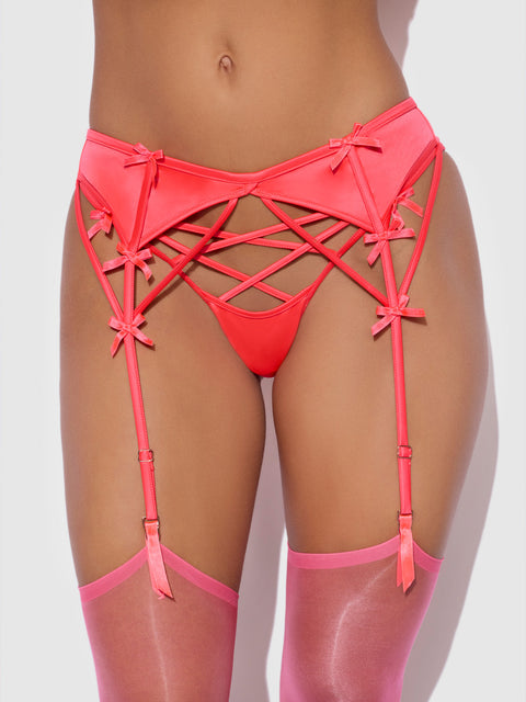 Petra Satin & Mesh Garter Belt featuring a red crisscross mesh front, decorative bows, and adjustable straps attached to sheer red stockings.