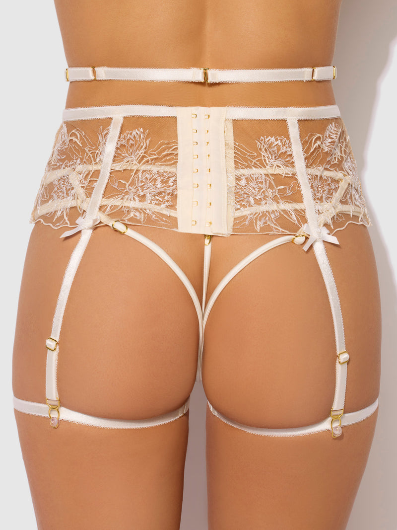 A person wears the Delfina Embroidered Garter Belt With Thigh Garters by Frederick's of Hollywood, featuring adjustable matching garters at the waist and thighs, viewed from behind against a light background.