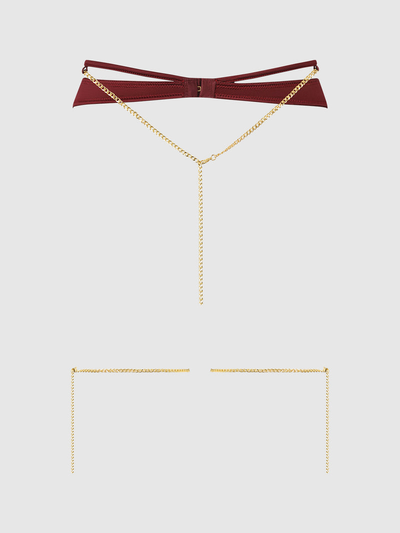A burgundy faux leather Emery Liquid Satin & Chain Thigh Garter Belt by Frederick’s of Hollywood, featuring gold-tone chains—including a central chain that drapes down and two separate gold chains positioned below—displayed on a plain white background.