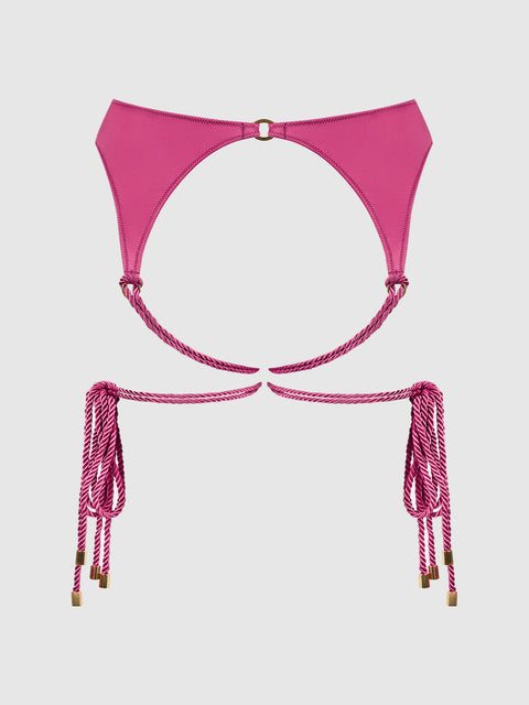 Introducing the Nadya Liquid Satin & Rope Garter by Frederick’s of Hollywood—a minimal and stylish garter in vivid pink satin, featuring luxurious rope-like straps with gold tips. Gold accents elevate the design, giving it a striking look that stands out against a plain white background.