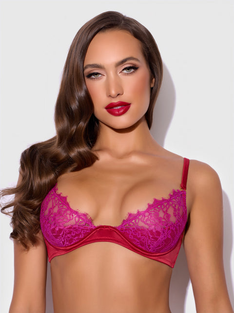 A woman with long brown hair and bold red lipstick models the Frederick's of Hollywood Rosalind Lace Cup Bra With Satin Half Cup, posing confidently against a plain light background.