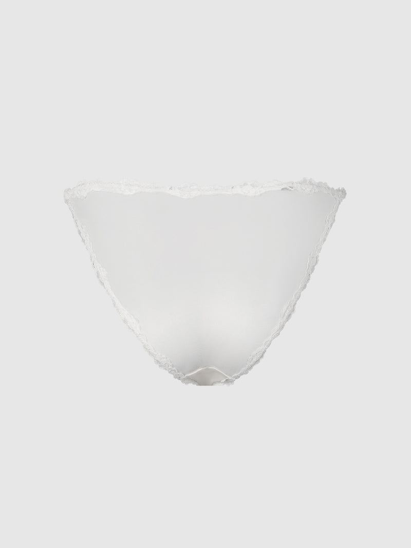 Frederick’s of Hollywood Marlena Satin & Lace String Bikini, delicately crafted in a translucent white fabric with irregular, lace-edged details, is displayed against a plain light gray background.