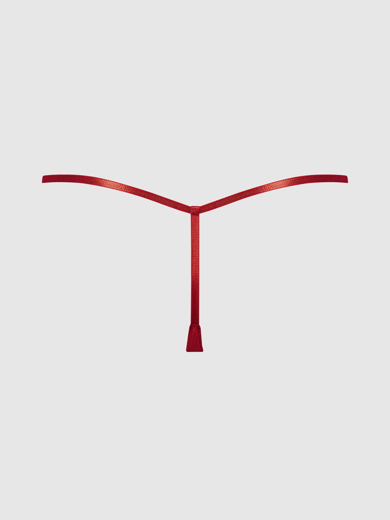 The Frederick’s of Hollywood Rising Star Liquid Satin Mini G-String, featuring a minimalist red T-shaped design with a center knot, is displayed on a plain light gray background.