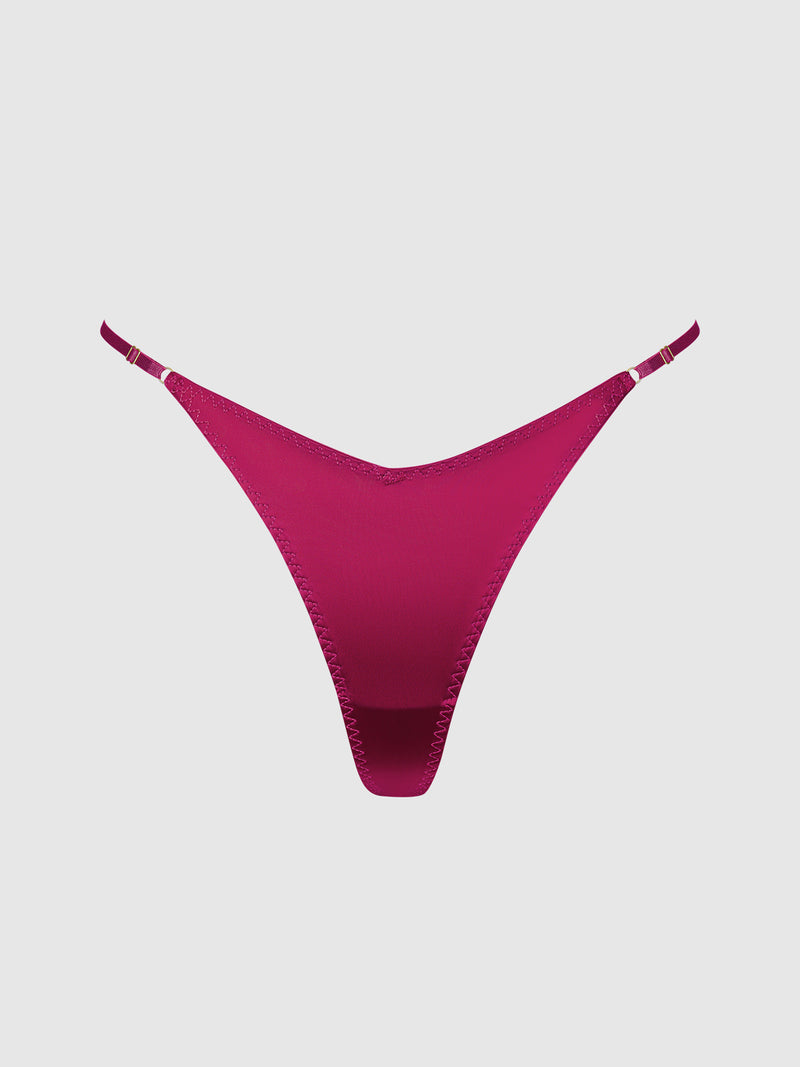 The Rising Star Liquid Satin Thong by Frederick’s of Hollywood, a magenta women’s thong with thin side straps, is displayed on a plain light background.
