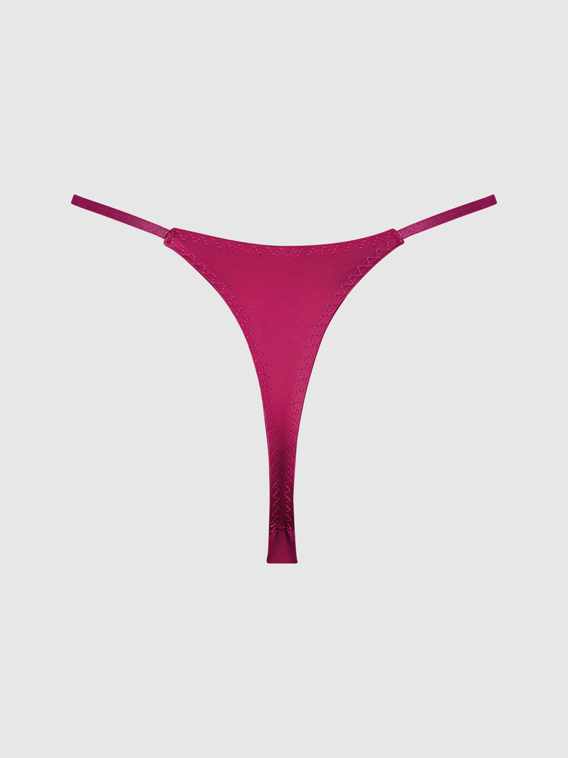 The Rising Star Liquid Satin Thong by Frederick’s of Hollywood, in a magenta shade with thin side straps, is displayed on a plain light gray background.