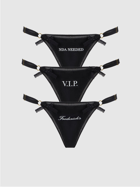 Frederick's of Hollywood Statement Cotton G-String 3 Pack features three black thongs with adjustable straps, each with unique white text—NDA NEEDED, V.I.P., and Fredericks. Ideal for panty packs or mix-and-match sets.
