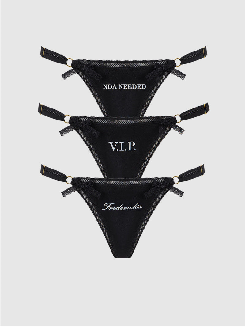 Frederick's of Hollywood Statement Cotton G-String 3 Pack features three black thongs with adjustable straps, each with unique white text—NDA NEEDED, V.I.P., and Fredericks. Ideal for panty packs or mix-and-match sets.
