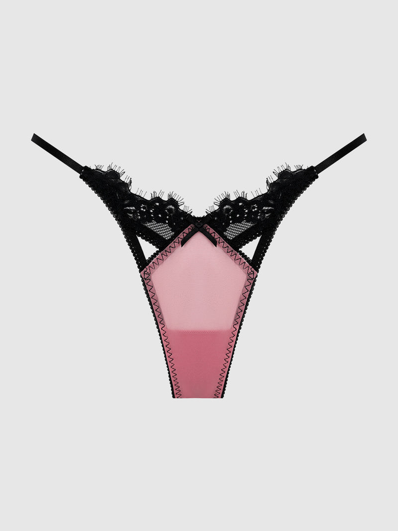 The Esme Pleated Chiffon & Lace Thong by Frederick’s of Hollywood features a sheer pink front panel and intricate floral lace detailing in black on the waistband, showcased against a light gray background.