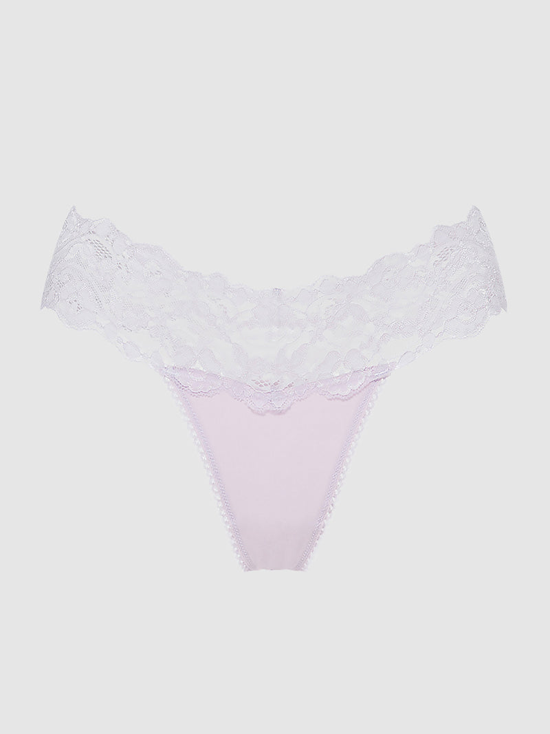 The Bridget Stretch Cotton & Lace Thong by Frederick's of Hollywood features light pink fabric with a wide, sheer white lace waistband, shown against a plain white background.