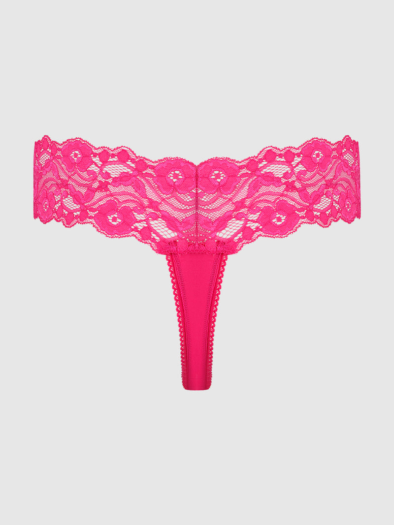 The Frederick's of Hollywood Bridget Stretch Cotton & Lace Thong features a bold pink hue, wide floral lace waistband, and sleek satin front panel, shown against a simple light background.
