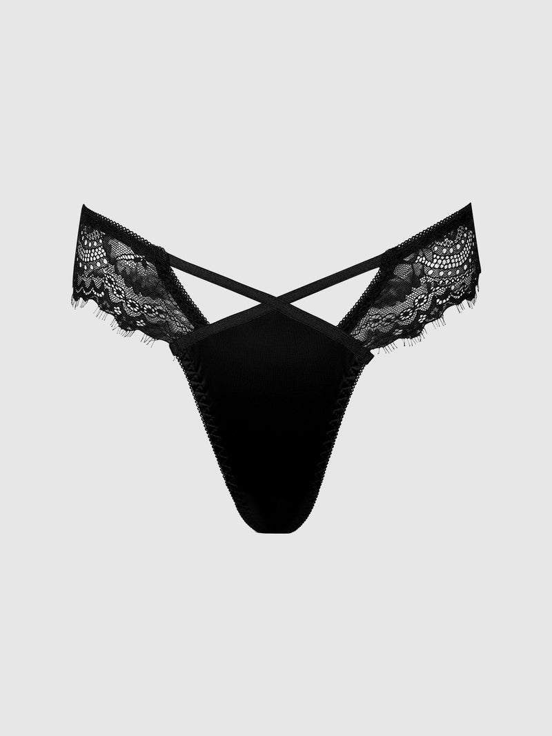 The Remi Satin & Lace Thong by Frederick's of Hollywood features black floral lace side panels and crisscross straps at the front, offering a minimal-coverage silhouette. The thong is displayed on a light gray background.