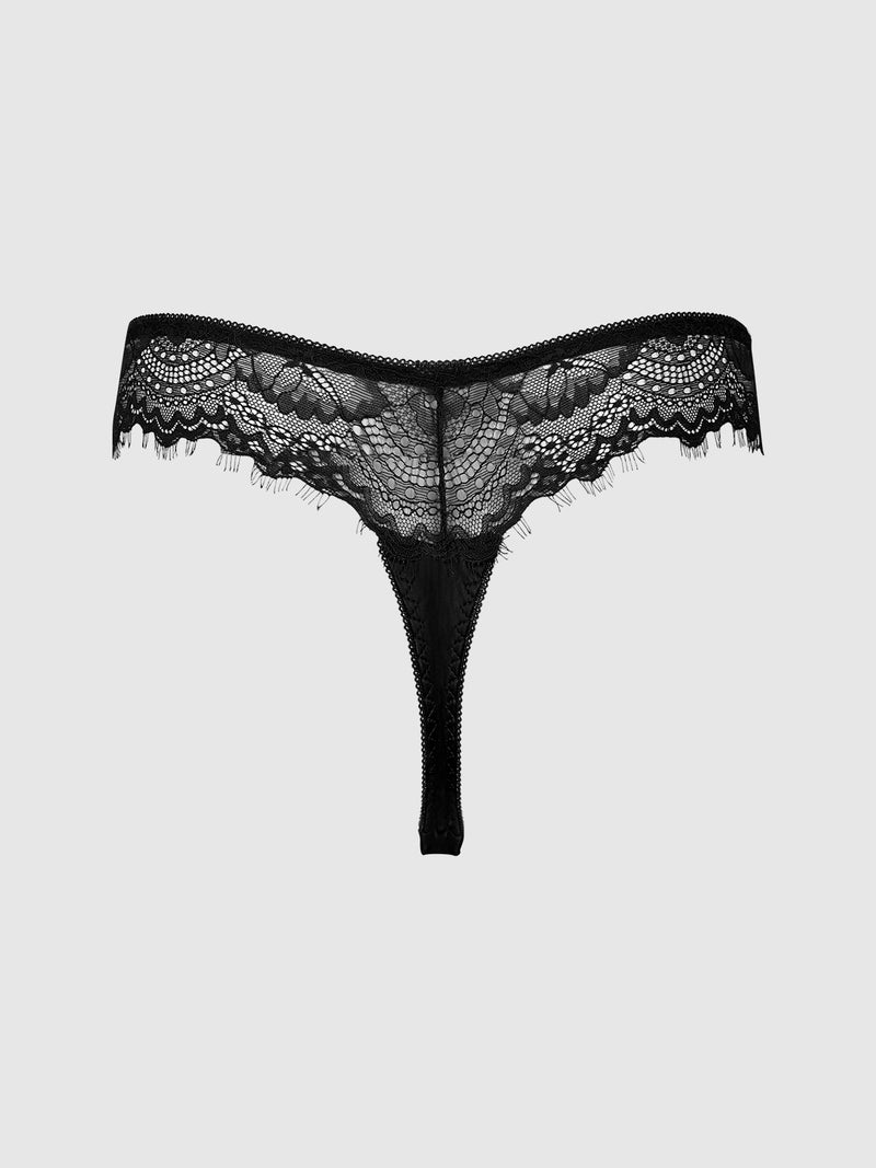 The Remi Satin & Lace Thong by Frederick's of Hollywood features black lace with floral patterns, sheer fabric, and scalloped edges for minimal coverage, showcased against a plain light gray background.