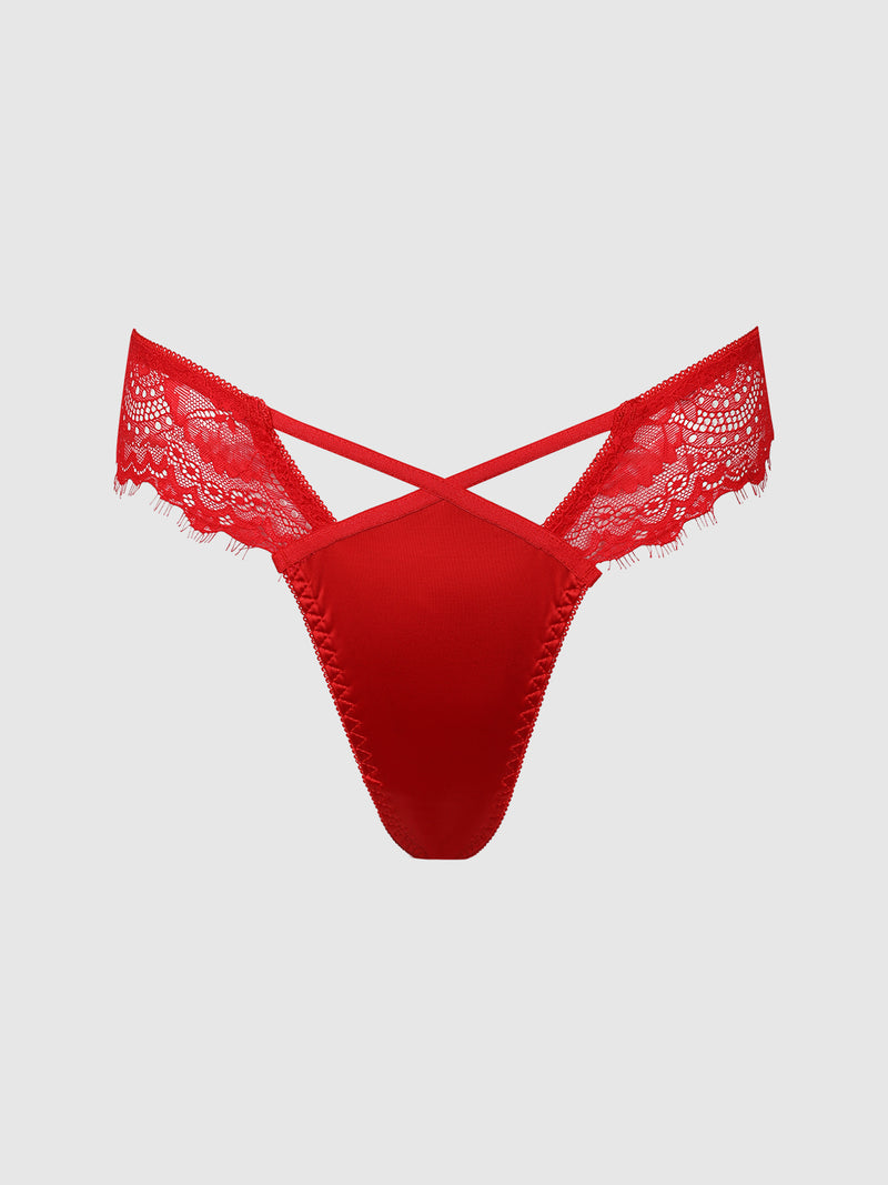 The Remi Satin & Lace Thong by Frederick's of Hollywood features crisscross straps at the front and delicate lace detailing on the sides, offering a minimal-coverage silhouette. It is showcased against a plain light gray background.