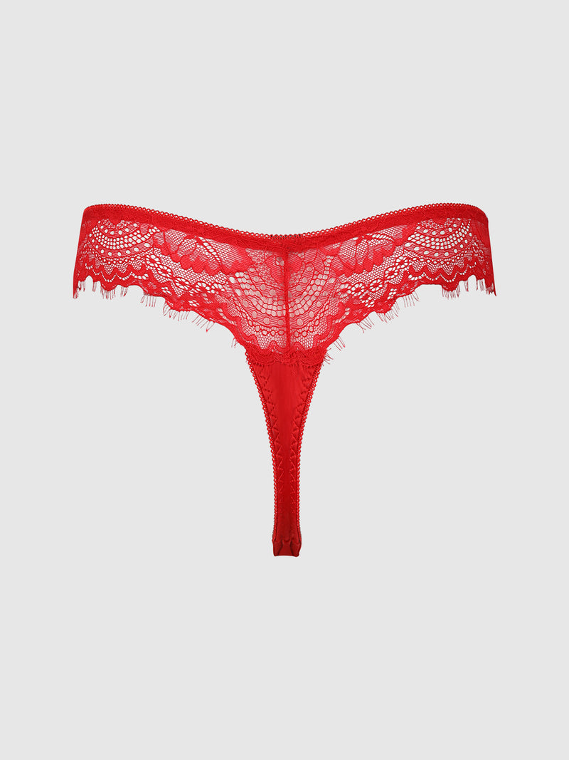 Remi Satin & Lace Thong by Frederick's of Hollywood, featuring intricate floral lace, scalloped edges, and a semi-sheer, minimal-coverage design in vibrant red, displayed on a plain light gray background.