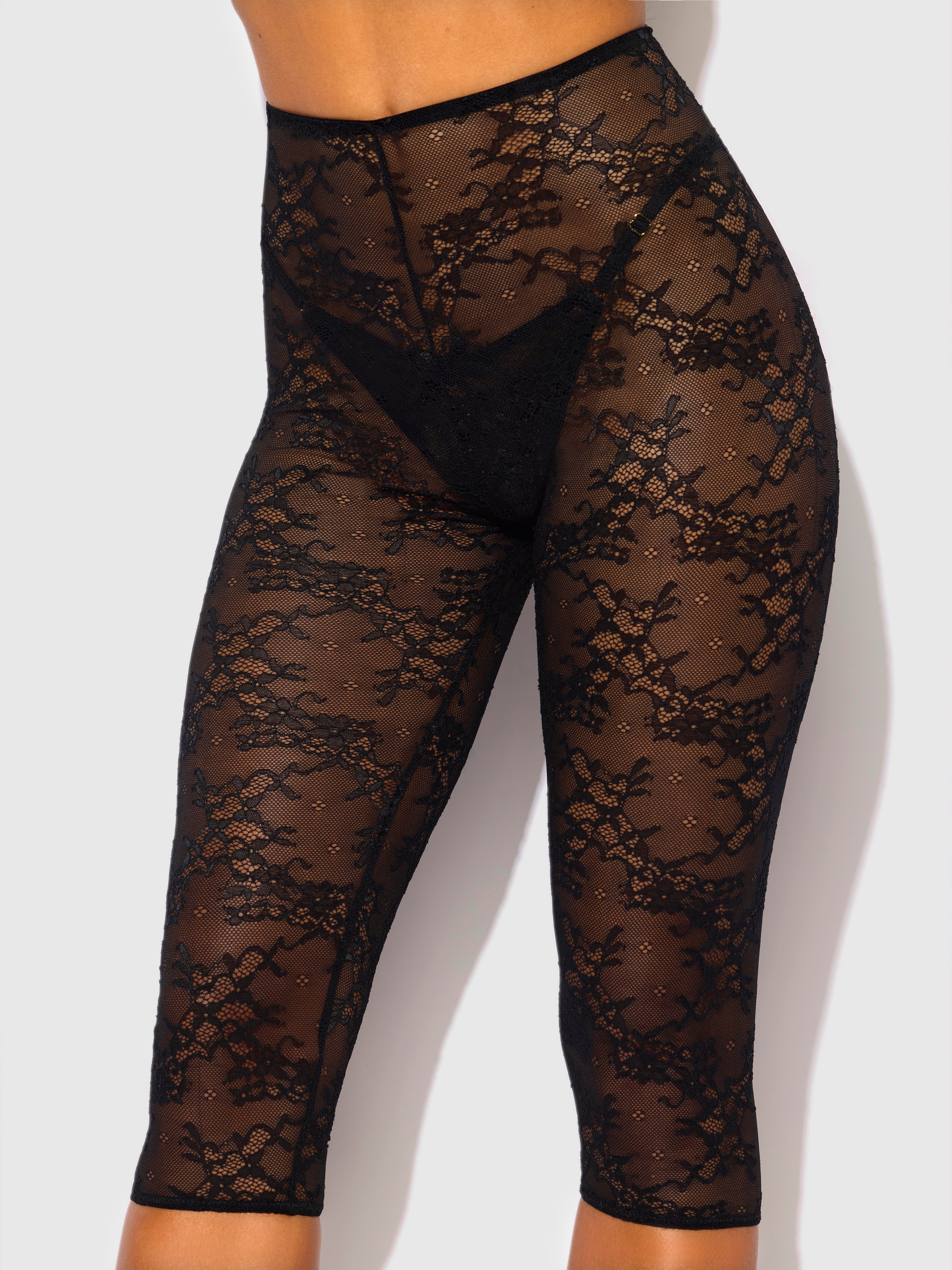 A person models the Frederick's of Hollywood Pia Lace Capri Legging Tights—high-waisted, sheer black lace with a floral pattern—shown from waist to below the knees against a plain light background.