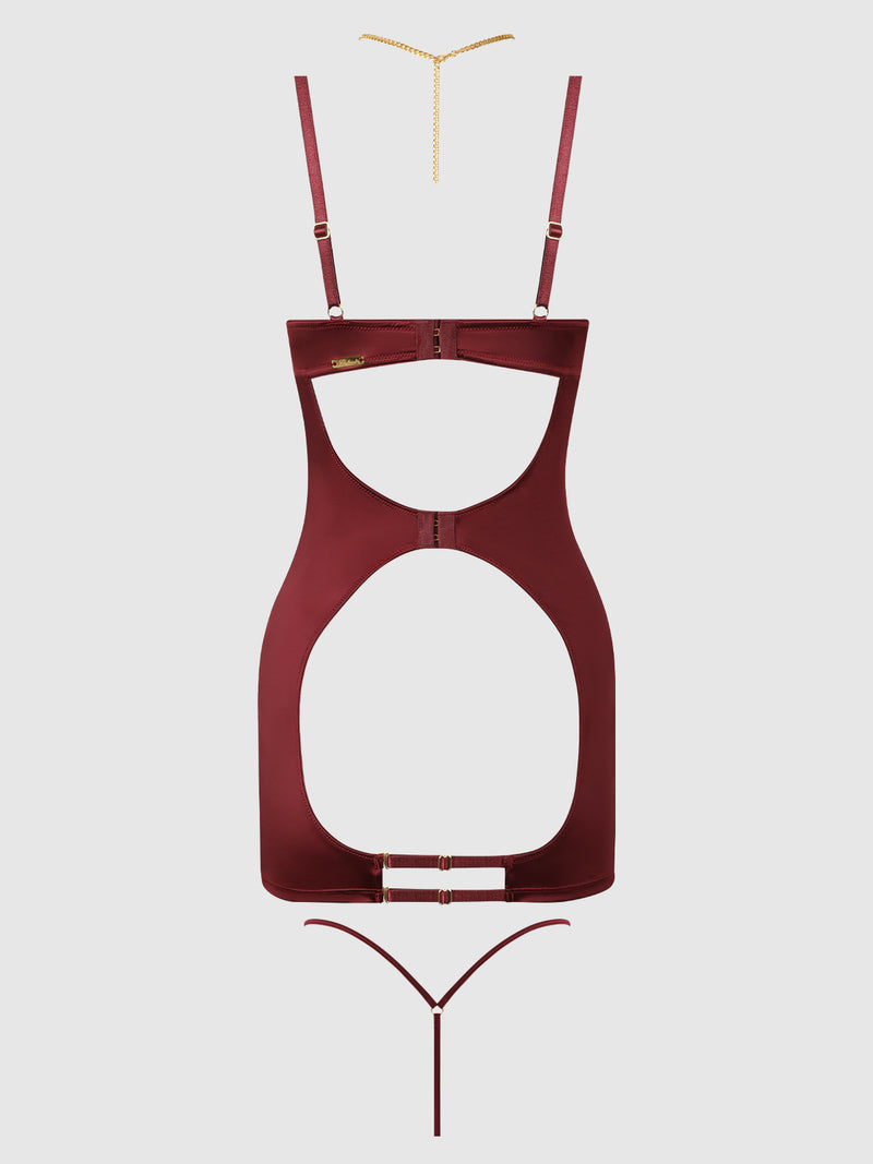 The Emery Liquid Satin & Chain Open Cup & Back Chemise Set by Frederick’s of Hollywood is shown in burgundy, featuring cut-out sides, gold hardware, adjustable straps, and a thin gold chain necklace displayed above. The background is plain light gray.