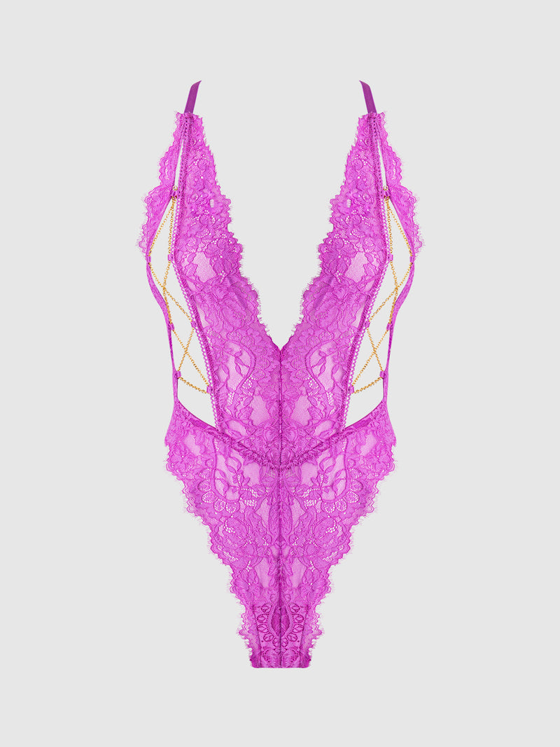 The Arianna Lace & Chains Plunge Teddy by Frederick's of Hollywood features vibrant fuchsia lace, a deep V-neckline, thin straps, gold chain sides, and scalloped edges, shown against a white background.