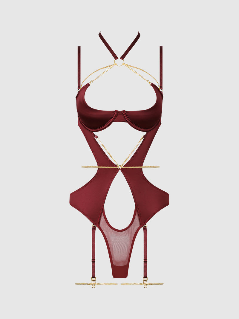 The Emery Liquid Satin & Chain Halter Teddy by Frederick’s of Hollywood features a burgundy strappy silhouette with gold chain accents, harness-inspired details, waist cutouts, mesh panels, and garter straps, displayed on a plain white background.