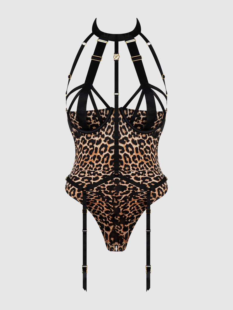 The Frederick's of Hollywood Raven Strappy Crotchless & Backless Teddy features leopard print, black strappy harness details, gold hardware, and attached garter straps, shown on a plain light gray background.