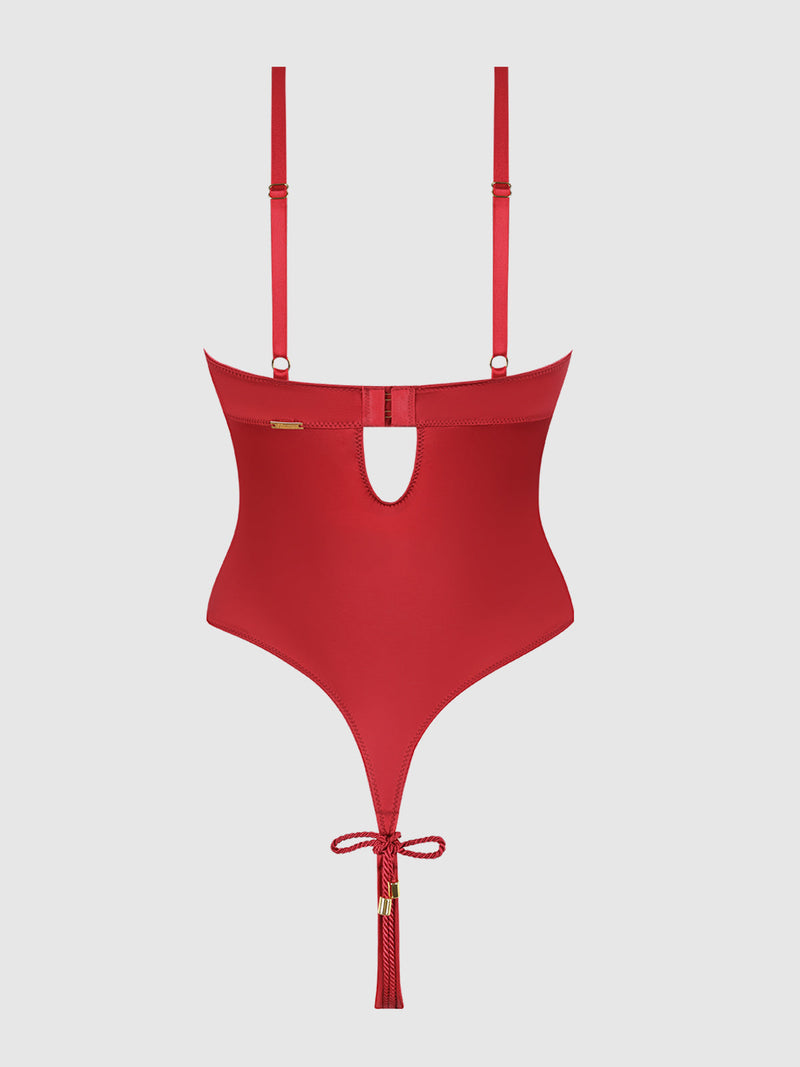The Nadya Liquid Satin & Rope Crotchless Teddy by Frederick's of Hollywood features red satin, high-cut sides, adjustable straps, a back keyhole cutout, and a tassel bow at the bottom. Displayed on a plain white background.