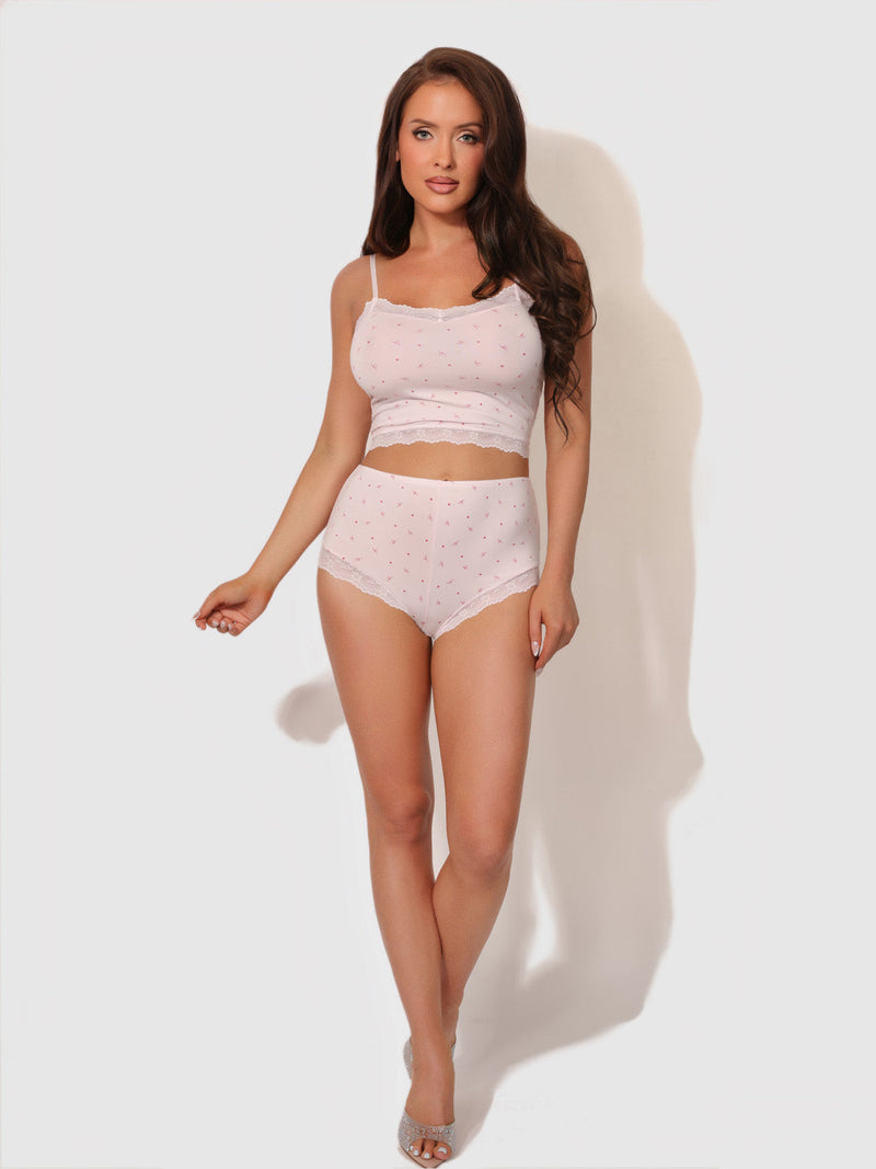 A woman wearing a pale pink, floral-patterned Seraphina Modal & Lace Cami & Short Sleep Set featuring high-waisted shorts with lace trim.
