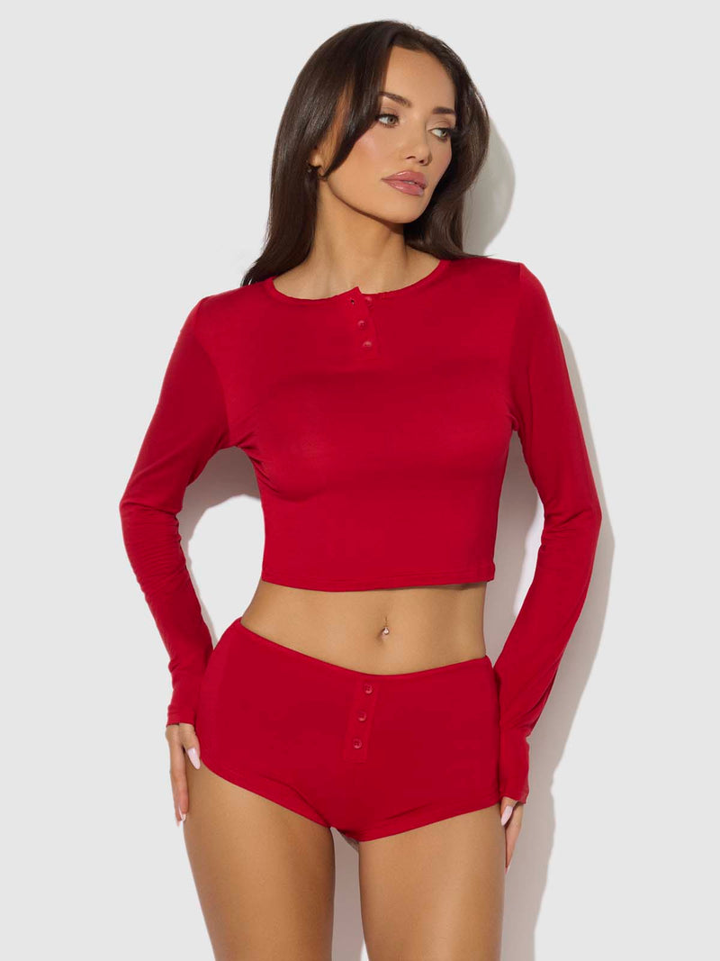 A woman wearing a red Seraphina Modal Long Sleeve Crop And Short Sleep Set featuring a long-sleeve henley crop top and matching shorts with a button-front detail.