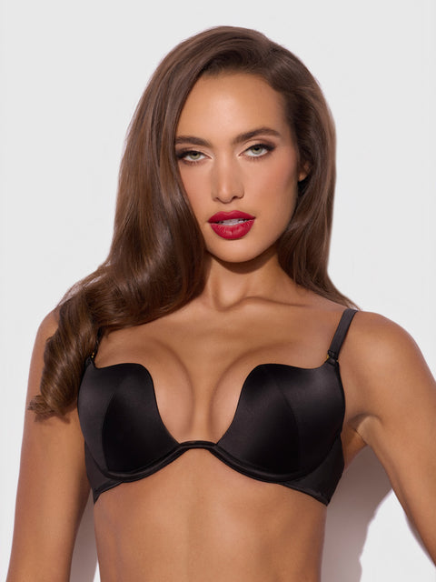 A woman wearing a black satin Frederick’s of Hollywood Petra Rising Star Plunge Push Up Bra.