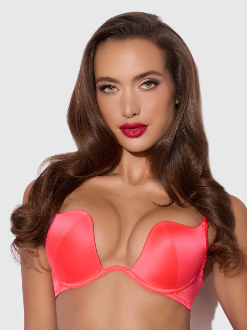 A woman wearing a vibrant pink Frederick’s of Hollywood Petra Rising Star Plunge Push Up Bra.