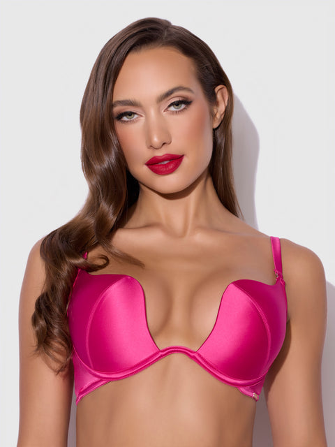 A woman with long, wavy brown hair wears the Frederick's of Hollywood Rising Star Plunge Push Up Bra in Petra Satin and bold red lipstick, posing against a plain light gray background.