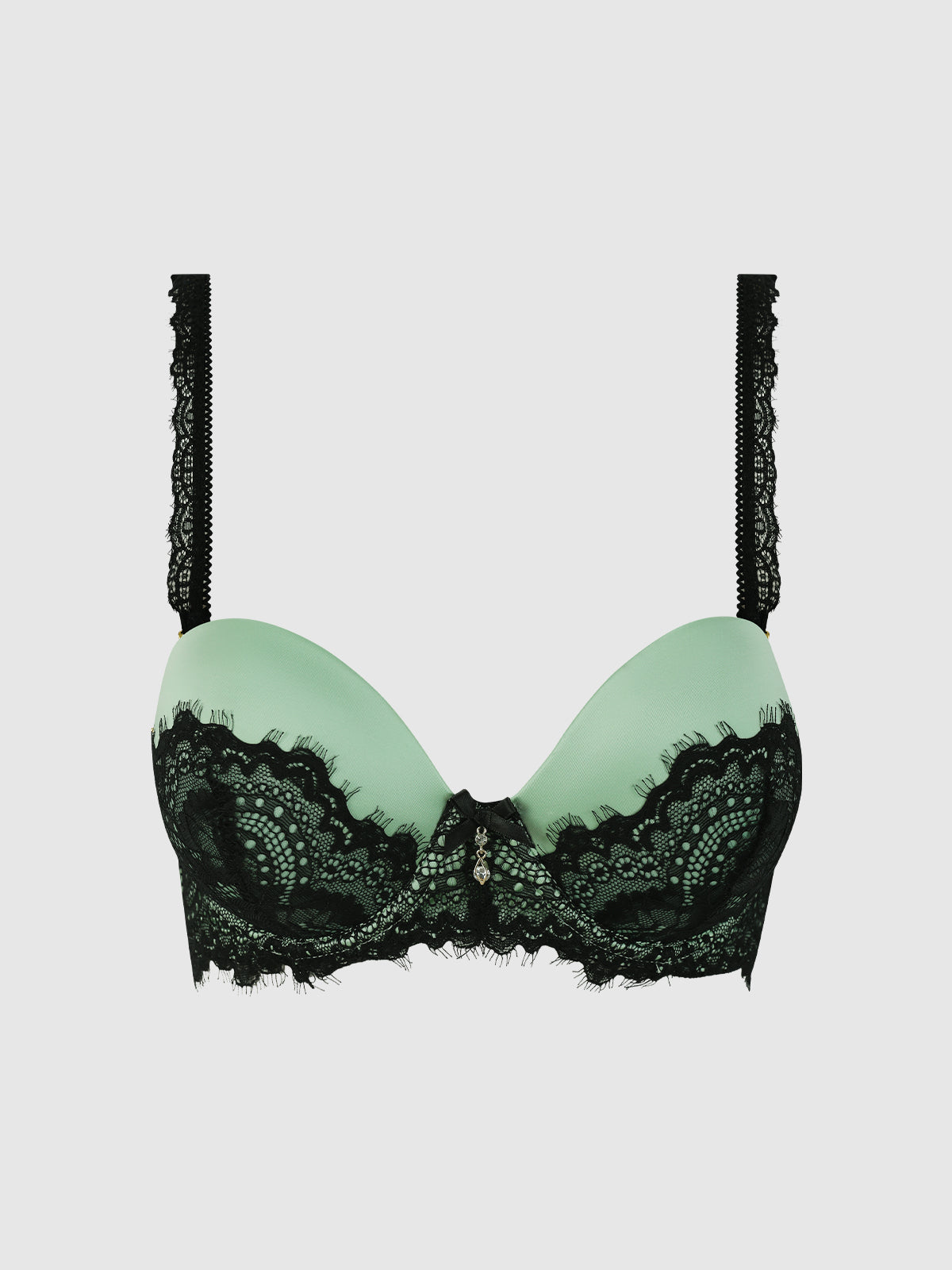 The Lexi Lace Strapless Push Up Bra by Frederick's of Hollywood features padded cups with a black lace overlay and decorative black lace straps, shown in light green on a plain light gray background.