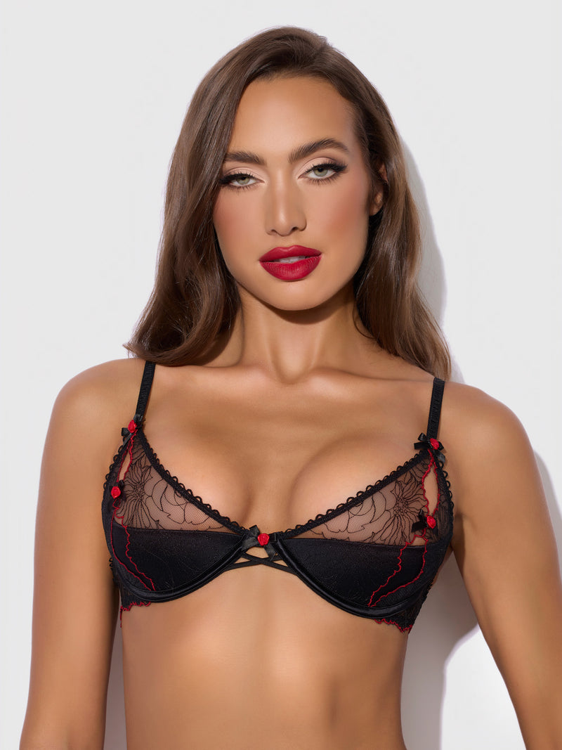 A woman with long brown hair, wearing the Frederick's of Hollywood Ilaria Embroidered Tulle Slit Cup Bra, looks directly at the camera with a neutral expression against a plain light background.