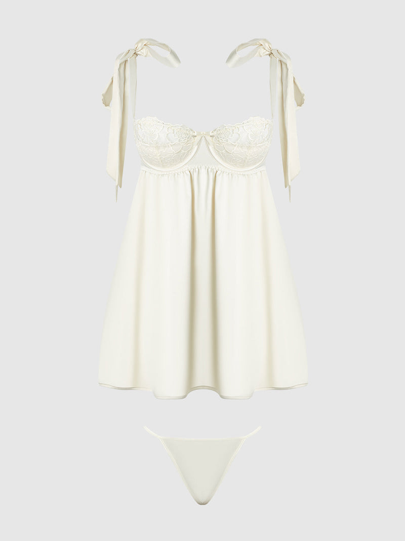 The Melrose Satin & Embroidered Lace Underwire Babydoll Set by Frederick's of Hollywood features a cream floral babydoll dress with ribbon tie straps and matching thong, displayed on a plain light gray background.