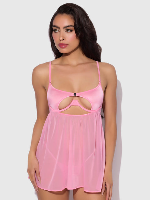 A woman models the Frederick's of Hollywood Neev Oil Slick Openable Cup Underwire Babydoll in light pink, featuring thin straps and a cut-out under the bust, set against a plain light background.