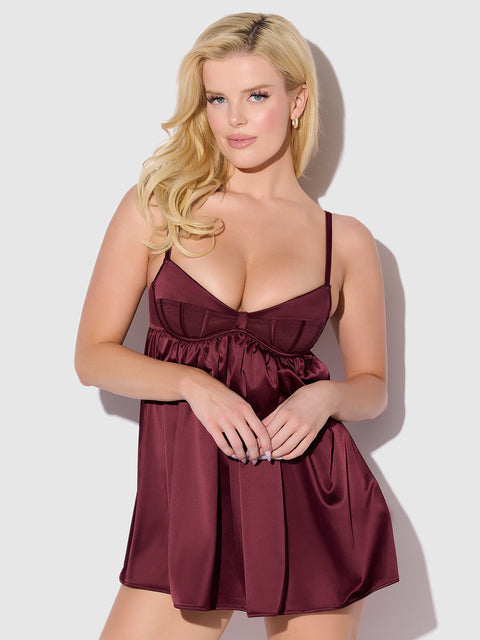 A person with long blonde hair poses against a light background, wearing the Frederick's of Hollywood Petra Satin & Mesh Unlined Corset Cup Babydoll Set, featuring thin straps and unlined cups.