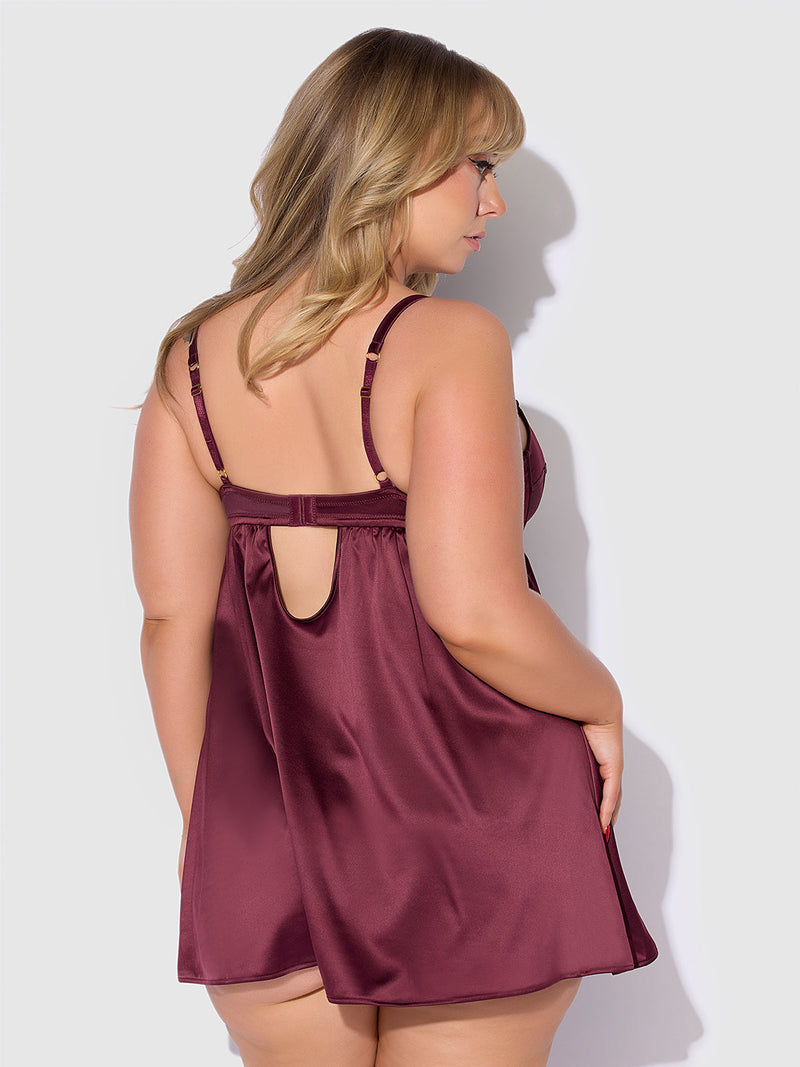 A woman with blonde hair is seen from the back, wearing the Frederick's of Hollywood Petra Satin & Mesh Unlined Corset Cup Babydoll Set in burgundy, featuring adjustable straps and a keyhole detail.