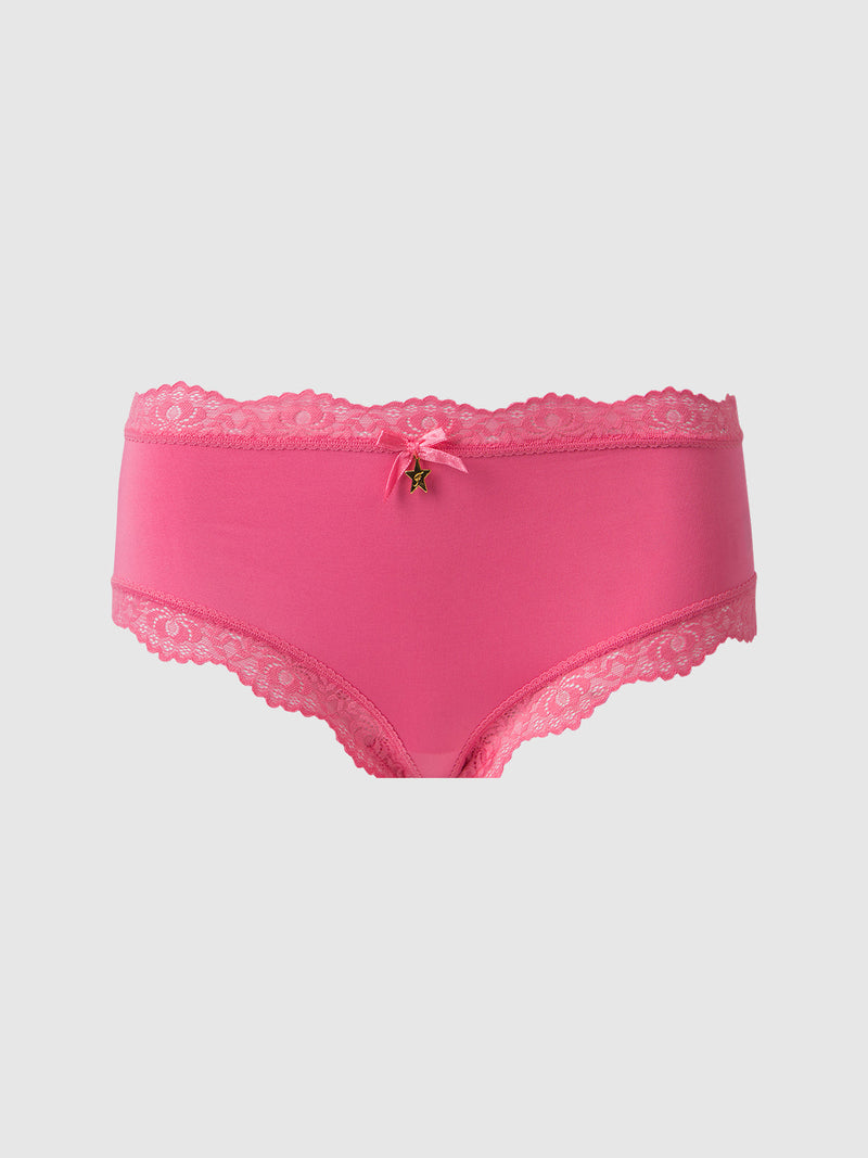 The Jenna Micro Cheeky by Frederick's of Hollywood is a bright pink panty with lace trim at the waistband and legs, finished with a small bow and charm at the front center. Set against a plain light gray background.