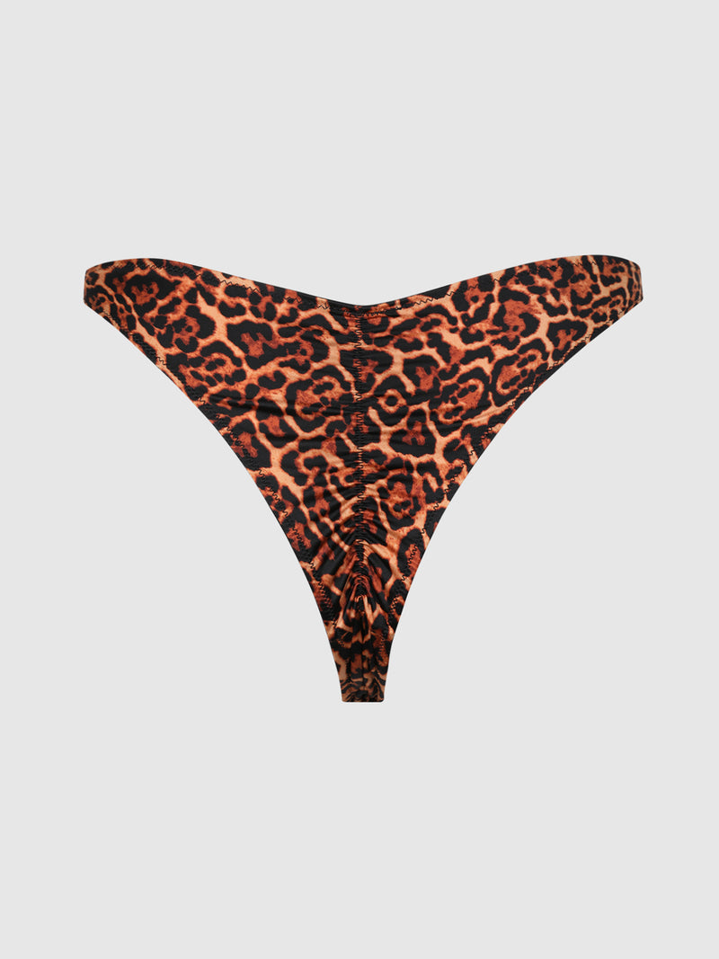 The Frederick's of Hollywood Rising Star Liquid Satin Crotchless Tanga features a high-cut design with a bold orange and black leopard print, gathered fabric at the center front, and is showcased on a plain light gray background.