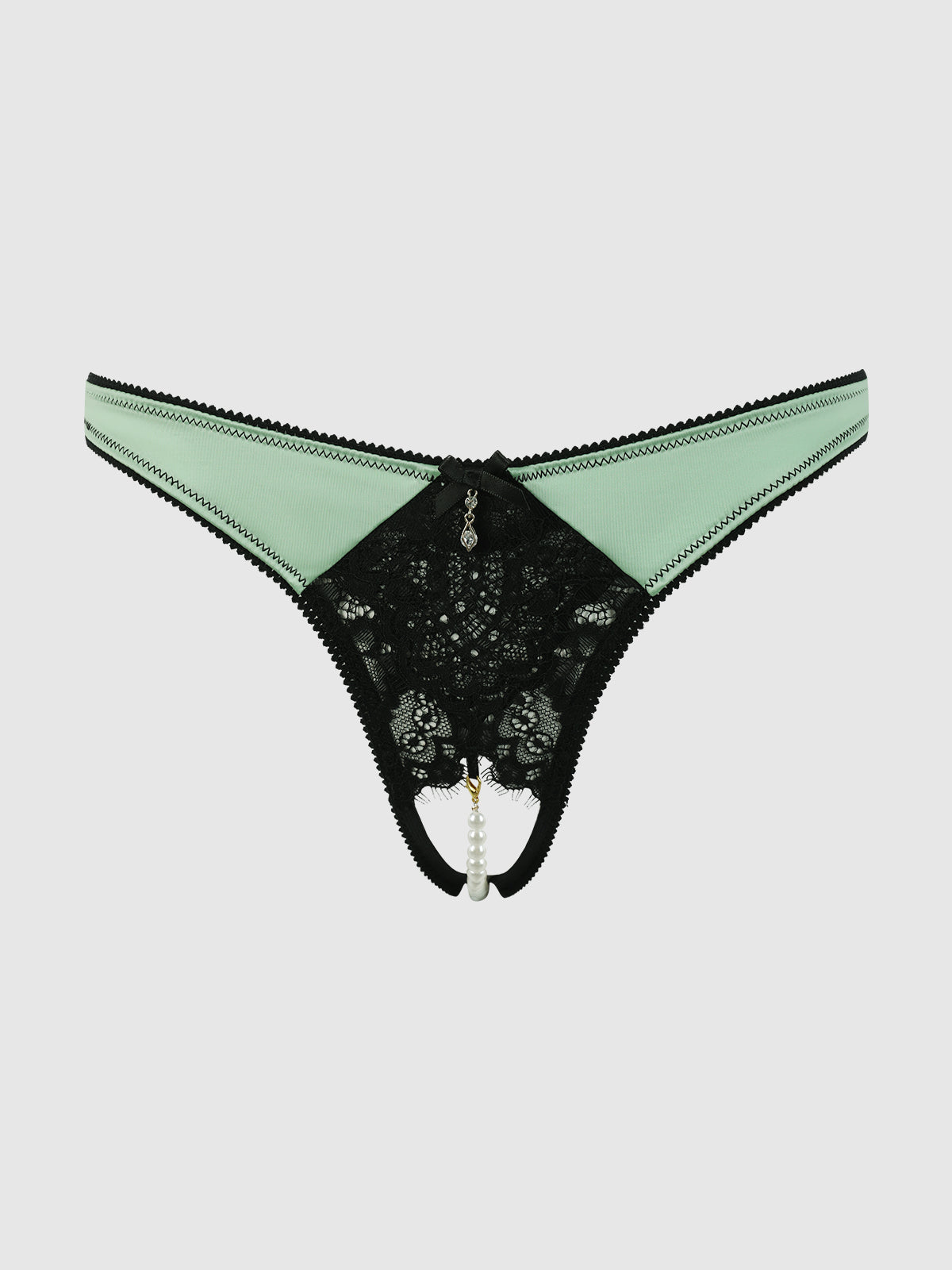 The Lexi Lace Liquid Satin Open Back Hipster by Frederick's of Hollywood features mint green and black lace, a cutout front with pearl detail, and decorative stitching, shown on a plain light background.