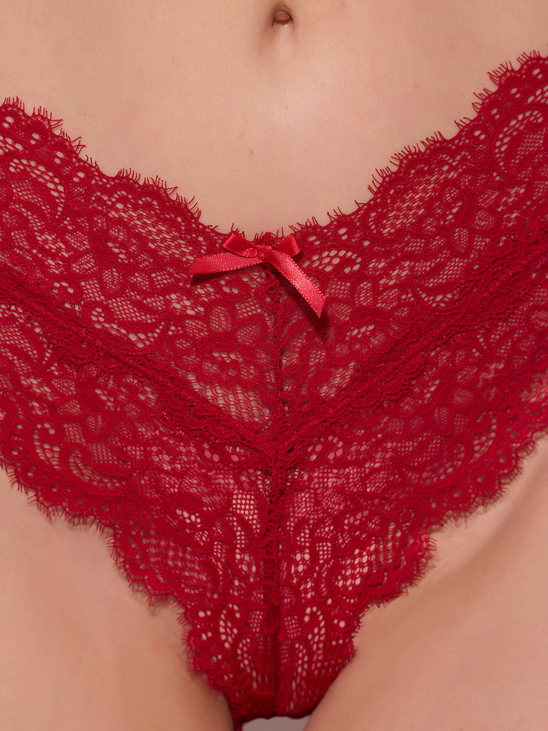 A close-up of a person’s lower abdomen and hips wearing Frederick's of Hollywood Lulu Lace V-Cheeky underwear in red with figure-flattering stretch lace and a small front bow.