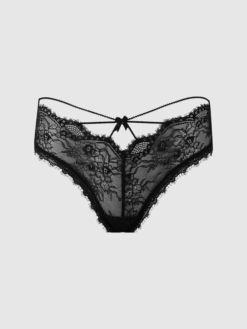 The Frederick’s of Hollywood Charlotte Lace & Mesh Hipster features black lace with a floral pattern, sheer detailing, scalloped edges, and a small bow at the center waistband, displayed on a plain light gray background.