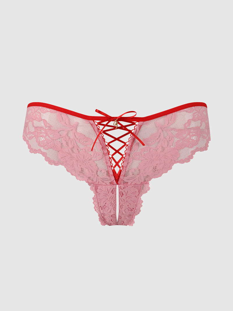 The Mabel Lace Up Front Crotchless Tanga by Frederick's of Hollywood features pink stretch lace with floral patterns, a red waistband, and a front ribbon lace-up detail, shown against a plain light background.
