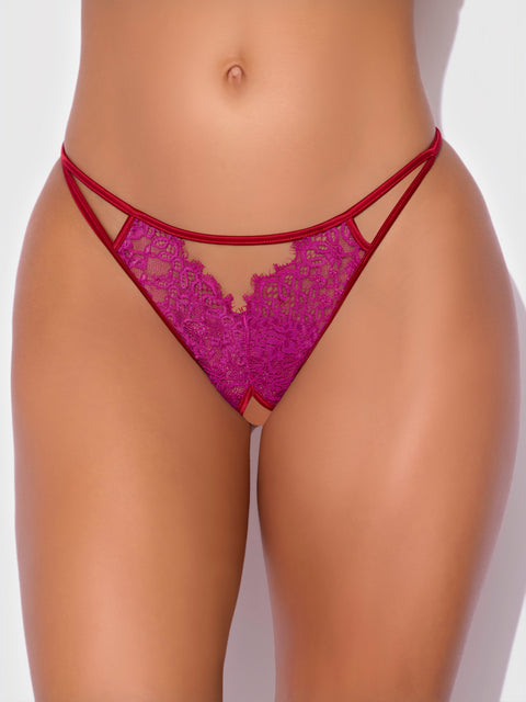 A close-up of a person’s midsection features the Frederick's of Hollywood Rosalind Lace & Satin Crotchless G-String in magenta, showcasing its thin straps and sheer lace detailing. The image focuses on the lingerie’s elegant design.
