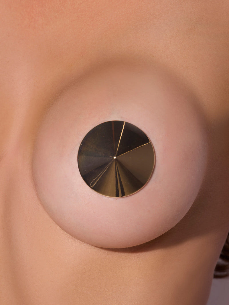 A close-up of a bare chest adorned with Frederick’s of Hollywood’s High Shine Metal Cone Pasties—metallic, circular nipple covers reminiscent of Madonna’s iconic cone-shaped style.