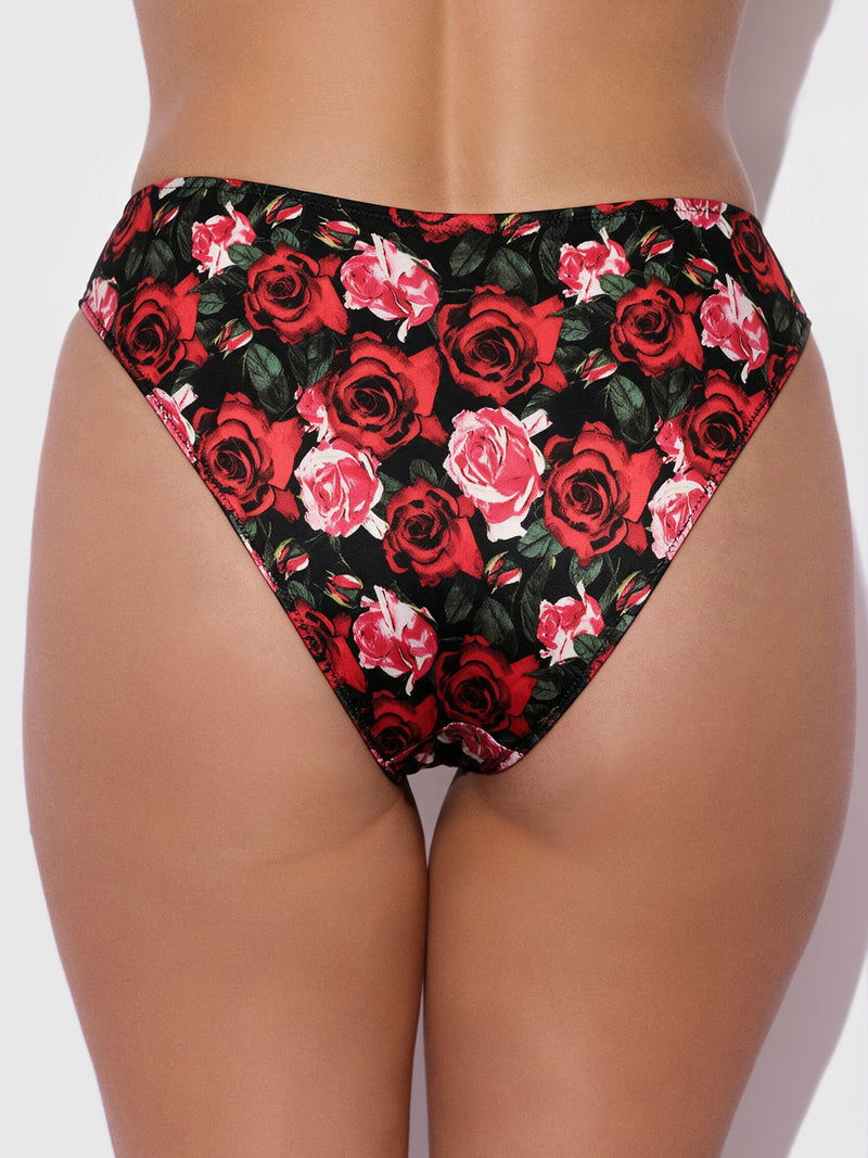 A person wearing the Frederick’s of Hollywood Lexi Liquid Satin Hipster, featuring a red and pink rose floral pattern on a black background, shown from the back.