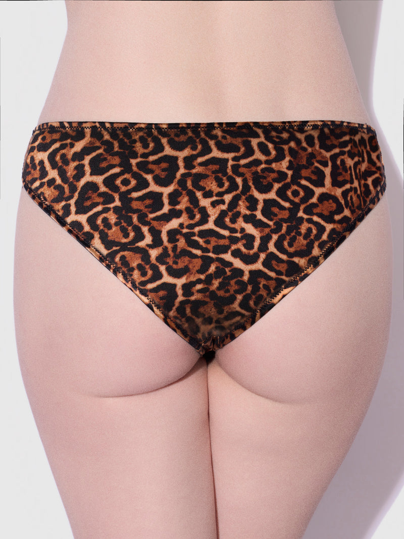 A person wearing Lexi Liquid Satin Hipster bikini bottoms by Frederick's of Hollywood in leopard print is shown from the waist down, facing away from the camera, against a plain background.