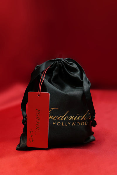 Black drawstring bag with a red tag featuring Frederick's of Hollywood on a red background