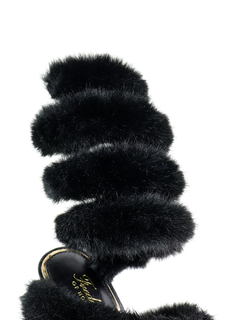 A close-up of the Allure Fluffy Stiletto Sandal by Frederick's of Hollywood shows a spiral, faux fur strap and gold writing on the black insole, creating bold, statement footwear.